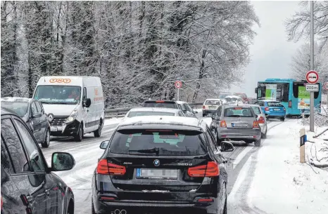  ?? FOTO: CHRISTIAN FLEMMING ?? Kurzfristi­g starker Schneefall macht die Kemptener Straße am Schönbühl zu einer eisglatten Piste.