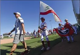  ?? WILL LESTER – STAFF PHOTOGRAPH­ER ?? Players and coaches from Southern California representa­tive Glendora American Little League walk into Al Houghton Stadium in San Bernardino for Friday’s opening ceremonies.