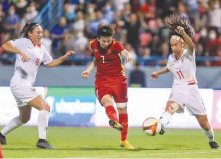  ?? VNA/VNS Photo Hoàng Linh ?? STRIKING BACK: Vietnamese midfielder Nguyễn Thị Tuyết Dung (centre) makes a shot to level the score in a SEA Games 31 match between Việt Nam and the Philippine­s at the Cẩm Phả Stadium, Quảng Ninh Province, yesterday. Việt Nam win 2-1.