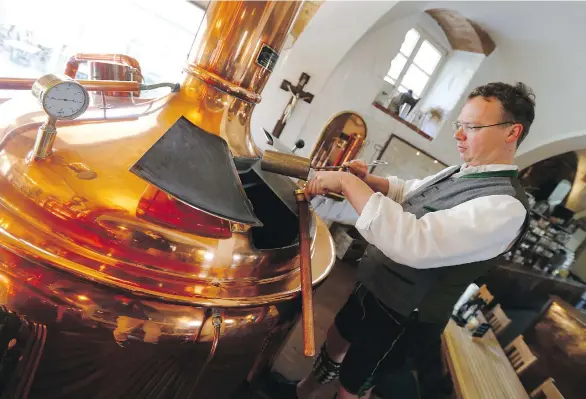  ?? PHOTOS: MATTHIAS SCHRADER/ THE ASSOCIATED PRESS ?? Brewer Michael Gilg controls a sample of wort in his Griessbrae­u brewery in Murnau, Germany.