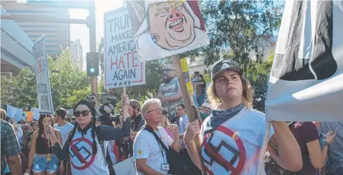  ?? Picture: AFP ?? FIGHTING HATE: Anti-racism protesters outside the Phoenix Convention Centre in Arizona before Mr Trump’s speech.