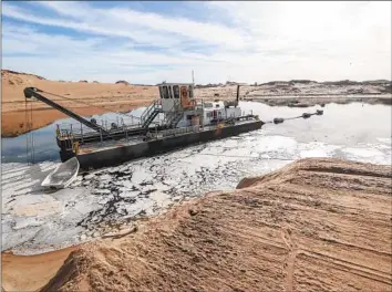  ?? Robert Gauthier Los Angeles Times ?? A DREDGING VESSEL on the beach in Marina, Calif., where a controvers­ial sand mine is finally closing after a century of operation. Scientists estimate the mine has eroded an average of 4 feet of coast a year.