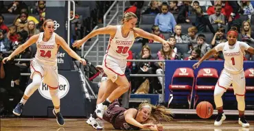  ?? DAVID JABLONSKI / STAFF ?? Dayton’s Ashleigh Parkinson (center) chases a loose ball Friday against Colgate at UD Arena. A crowd of 8,811 saw the Flyers women rally in the fourth quarter to open their 50th season with a 67-58 win.