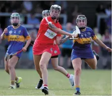  ?? INPHO ?? Cork’s Ashling Thompson scoresa point despite the efforts of Tipperary’s Laura Loughnane