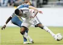  ?? GERRY KAHRMANN/ PNG ?? Gershon Koffie of the Vancouver Whitecaps and Mike Magee of the L. A. Galaxy, left, battle for the ball during Saturday’s match.