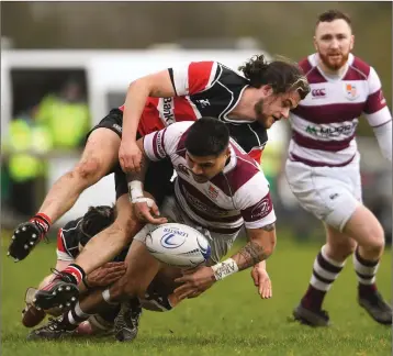  ??  ?? Tino Mafoe of Tullow is tackled by Wicklow’s Jonathon Hopkins, left, and Andy Doyle.