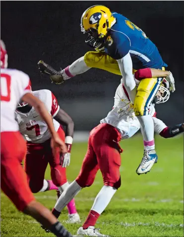  ?? SEAN D. ELLIOT/THE DAY ?? Ledyard’s Justin Carter (3) tries to hurdle NFA’s Isaiah Price during the Colonels 20-0 win on Friday night.