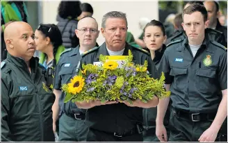  ??  ?? Staff from the London Ambulance Service lay flowers in remembranc­e