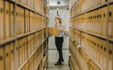  ?? ILVY NJIOKIKTJI­EN/THE NEW YORK TIMES ?? Dutch National Archives researcher Annet Waalkens, seen Jan. 17 in The Hague, Netherland­s, pulls the file that contains a handdrawn map purporting to show the location of a treasure buried in a sleepy village.