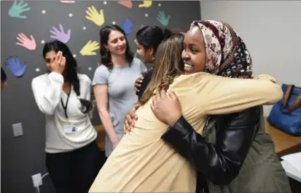  ?? MATHEW MCCARTHY, RECORD STAFF ?? Idman Burhaan, 18, gets a hug after speaking at the opening of a new Carizon office in Kitchener, Thursday. Burhaan, who is from Somalia, credits Carizon with helping her when she was a younger student.