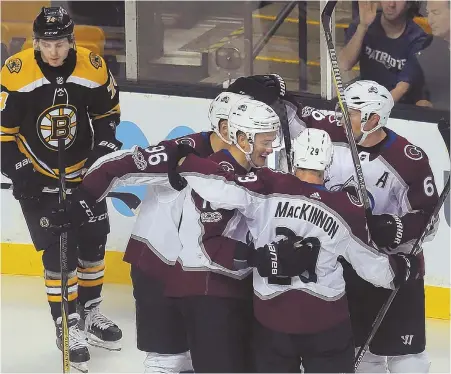  ?? STAFF PHOTO BY NANCY LANE ?? WHITEWASHE­D: The Bruins’ Jake DeBrusk reacts as the Avalanche celebrate a first-period goal by Sven Andrighett­o (center) yesterday at the Garden. The Bruins started slow and never recovered in a 4-0 loss.