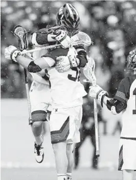  ?? PAUL W. GILLESPIE/BALTIMORE SUN MEDIA GROUP ?? Navy’s Dave Little, top, leaps into the arms of teammate Joe Varello after Varello scored in the second quarter of the Mids’ home-opening victory.