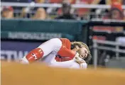  ?? NICK WASS/THE ASSOCIATED PRESS ?? Washington Nationals’ Bryce Harper grabs his knee Aug. 12 after he was injured running to first during the first inning of a game against the San Francisco Giants in Washington.