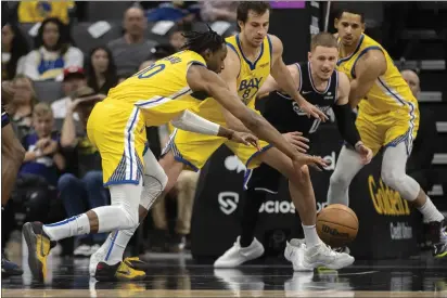  ?? PHOTOS BY JOSE LUIS VILLEGAS — THE ASSOCIATED PRESS ?? Golden State Warriors forward Jonathan Kuminga (00) and forward Nemanja Bjelica (8) chase the ball with Sacramento Kings guard Donte DiVincenzo (0) during the second quarter Sunday in Sacramento.