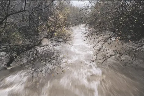  ?? NIC COURY VIA AP ?? THE CARMEL RIVER FLOWS HEAVILY AFTER RECENT RAINS in Carmel Valley, Calif., on Jan. 9. California Gov. Gavin Newsom has asked water regulators to change the rules to let state officials store more water from the recent weeks of heavy rain. Environmen­tal groups oppose the change, saying less water in the rivers would kill endangered species of fish.