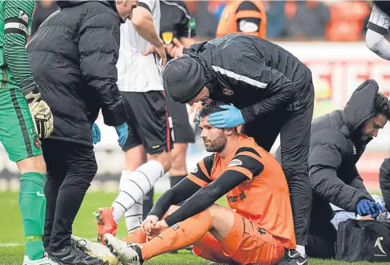  ??  ?? Mark Durnan receives treatment for a head knock which, ultimately, forced the Dundee United defender off against St Mirren.