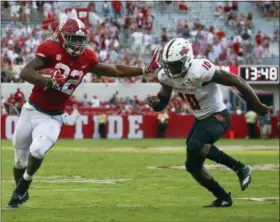  ?? BUTCH DILL — THE ASSOCIATED PRESS ?? Alabama running back Najee Harris (22) stiff arms Arkansas State defensive back Justin Clifton (10) as he carries the ball during the second half of an NCAA college football game, Saturday in Tuscaloosa, Ala. Alabama won 57-7.