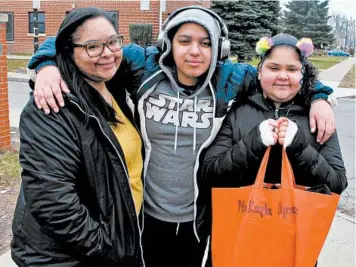  ?? CAROLYN THOMPSON/AP ?? Roxanne Ojeda-Valentin, left, with her children, Malachi and Makayla Ojeda, leave the kids’ school in Buffalo, New York, on March 17 with textbooks and assignment­s to work on while the district is closed due to the coronaviru­s.