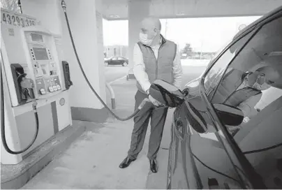  ?? STEVEN SENNE/AP ?? Jeremy Heskett pumps gasoline Feb. 18 in Westwood, Massachuse­tts. Gas prices have been on the rise for nearly a year.