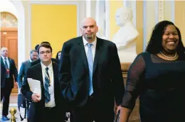  ?? PATRICK SEMANSKY/AP ?? Sen.-elect John Fetterman, D-Pa., walks on Capitol Hill in Washington during his orientatio­n Nov. 15. Fetterman has said that he will wear a suit in the Senate chamber, despite his usual garb of a hoodie and shorts.