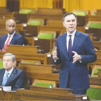  ?? ADRIAN WYLD / THE CANADIAN PRESS ?? With a limited number of MPS on hand and spread out, Finance Minister Bill Morneau responds to a question after tabling the government’s COVID-19 financial measures bill in the House of Commons on Wednesday.