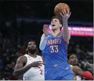  ?? SUE OGROCKI — THE ASSOCIATED PRESS ?? Oklahoma City Thunder center Mike Muscala shoots in front of Philadelph­ia 76ers center Joel Embiid, left, and forward Danuel House Jr. in the second half of a Dec. 31, 2022 game in Oklahoma City.