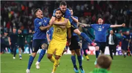  ?? (Reuters) ?? ITALY PLAYERS jump on goalkeeper Gianluigi Donnarumma (in yellow) in celebratio­n after the Azzurri captured the Euro 2020 title with a final shootout victory over England.