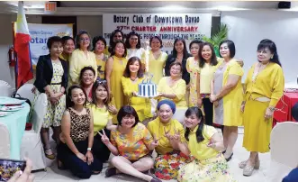  ??  ?? YELLOW belles symbolizin­g the Downtowner­s’ joy and optimism as they light the sparkler on their birthday cake