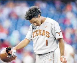  ?? Nati Harnik Associated Press ?? DAVID HAMILTON heads back to the dugout after striking out with the bases loaded, ending the Longhorns’ eighth-inning threat against Arkansas on Sunday.