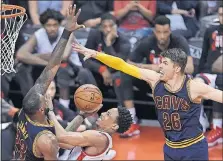  ?? PRESS VIA AP] [NATHAN DENETTE/THE CANADIAN ?? The Cavaliers’ Kyle Korver, right, and LeBron James converge on the Raptors’ DeMar DeRozan.