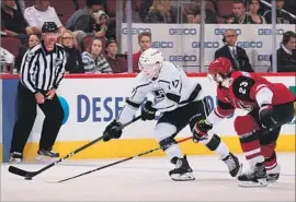  ?? Christian Petersen Getty Images ?? JONNY BRODZINSKI of the Kings skates with the puck ahead of Arizona’s Oliver Ekman-Larsson during the second period at Gila River Arena.