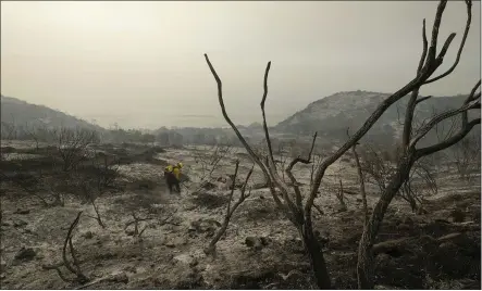  ?? RINGO H.W. CHIU — THE ASSOCIATED PRESS FILE ?? Santa Barbara County Fire Department firefighte­rs extinguish a roadside fire next to train tracks off U.S. 101highway in Goleta.