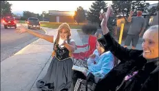  ?? Jenny sparks / Loveland Weekly ?? Anna from Arendelle (also known as Kaylynn Fischer), left, motions toward a surprise parade of cars with people wishing happy birthday to Olivia Perruzza, 14, center, on Thursday outside of Walt Clark Middle School in Loveland.