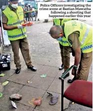  ?? ?? Police Officers investigat­ing the crime scene at Bastian Mawatha following a shooting that happened earlier this year