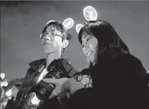  ?? Gary Coronado Los Angeles Times ?? SHINYA YOSHIDA, left, and Akiko Shiho, of Tokyo, wear glowing headbands at Disneyland to celebrate the parade’s return.