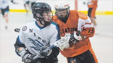  ?? JULIE JOCSAK THE ST. CATHARINES STANDARD ?? Trent Hunter of the Niagara Thunderhaw­ks keeps the ball away from Bo Peltier of the Six Nations Rebels in junior B lacrosse action at Meridian Credit Union Arena in Virgil on Tuesday.