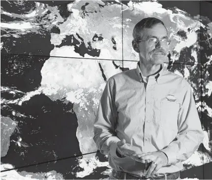  ?? BARBARA HADDOCK TAYLOR/BALTIMORE SUN ?? George Huffman, a research meteorolog­ist at the Goddard Space Flight Center, stands in front of the hyperwall, a 20-foot screen which displays satellite images of weather patterns around the earth.