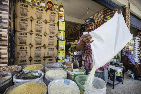  ?? AFP ?? A merchant sells grain at a market in Qamishli, north-east Syria. Economists say the country’s living standards are at their worst for 120 years