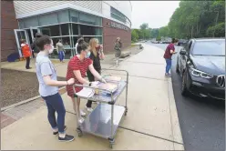  ?? Matthew Brown / Hearst Connecticu­t Media ?? Seniors are met by teachers and administra­tors as they drive up to Greenwich High School to receive their graduation packages Friday.