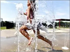  ?? SEAN MCKEAG — THE CITIZENS’ VOICE VIA AP ?? A girl runs through the splash pad in Coal St. Park in Wilkes-Barre, Pa. on Tuesday.