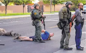  ?? ADOLPHE PIERRE-LOUIS/ JOURNAL ?? Steven Ray Baca, center, and members of the New Mexico Civil Guard are taken into custody by Albuquerqu­e Police Department officers following a shooting at a protest calling for the removal of a Juan De Oñate statue.