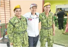  ??  ?? Mojigoh (centre) flanked by the uniformed personnel in Sembulan during the district Hari Merdeka celebratio­n yesterday.