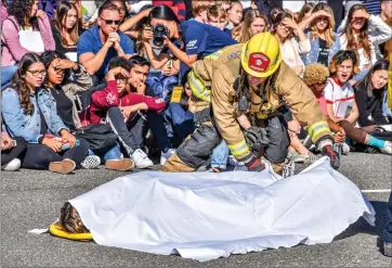  ?? Brennon Dixson/The Signal ?? During a demonstrat­ion, a Los Angeles County firefighte­r from Station 126 covers a student’s body to signify the ramificati­ons of driving distracted or under the influence of controlled substances.