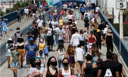  ?? Photograph: Caroline Brehman/EPA ?? People on the Santa Monica Pier in Los Angeles on 12 August.