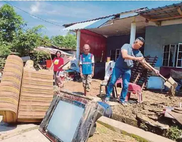  ?? NSTP PIC BY ROSMAN SHAMSUDIN ?? Kampung Orang Asli Chinggong villager Jefri Mohd Kassim (centre) looking at the mess and damaged appliances after the village in Tanjung Malim, Perak, was flooded yesterday.