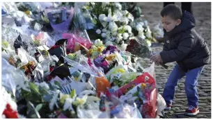  ??  ?? Moving tribute: A child lays flowers close to the Clutha Vaults pub