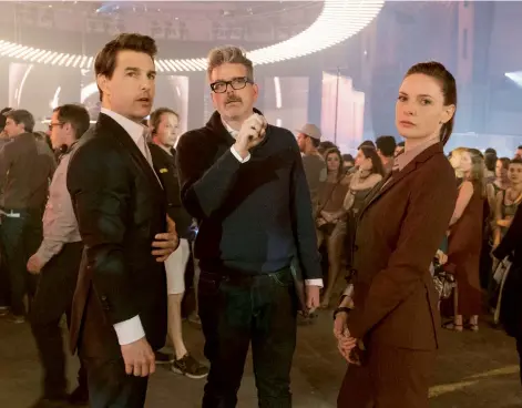  ??  ?? Director McQuarrie speaks to his leading stars, Tom Cruise and Rebecca Ferguson on the Fallout set