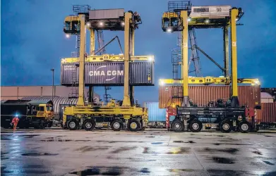  ?? ANDREW TESTA/THE NEW YORK TIMES ?? Shipping containers filled with thousands of bottles of wine are loaded onto a freight train Saturday at Tilbury Docks in London. As Britain continues to face problems in its supply chain, distributo­rs and retailers are looking for creative fixes.