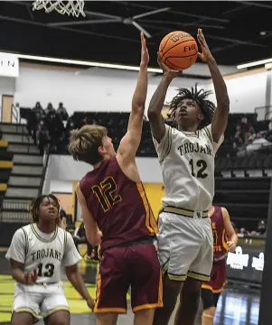  ?? The Sentinel-Record/Grace Brown ?? Q Hot Springs’ Jayveon Felton (12) goes up for a basket as Lake Hamilton’s Cade Robinson (12) defends during Tuesday’s game at Trojan Arena.