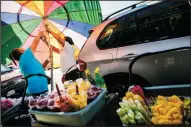  ?? MARCUS YAM/LOS ANGELES TIMES ?? Street vendors fix their sun umbrella as they sell fruit in Los Angeles’ Fashion District in a 2015 file image.